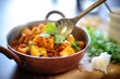 © studioworkstock - spoon serving aloo gobi from a copper pot