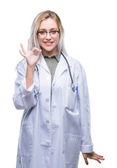 Poster - Young blonde doctor woman over isolated background smiling positive doing ok sign with hand and fingers. Successful expression.