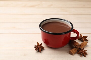 Sticker - Tasty hot chocolate and spices on light wooden table, closeup. Space for text