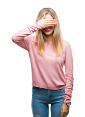 Sticker - Young beautiful blonde woman wearing pink winter sweater over isolated background smiling and laughing with hand on face covering eyes for surprise. Blind concept.