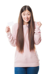 Sticker - Young Chinese woman over isolated background holding visit card screaming proud and celebrating victory and success very excited, cheering emotion