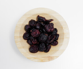 Wall Mural - wooden bowl of dried cranberries on white background