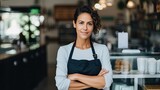 Fototapeta  - Smiling female barista in a casual uniform in a modern cafe.