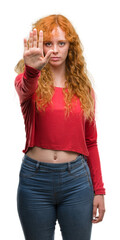 Wall Mural - Young redhead woman with open hand doing stop sign with serious and confident expression, defense gesture