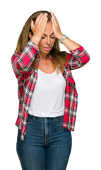 Wall Mural - Middle age adult woman wearing casual shirt over isolated background suffering from headache desperate and stressed because pain and migraine. Hands on head.