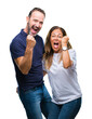 © Krakenimages.com - Middle age hispanic casual couple over isolated background very happy and excited doing winner gesture with arms raised, smiling and screaming for success. Celebration concept.