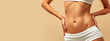 © edojob - woman's toned midsection against a beige background, wearing a white undergarment or sportswear, exemplifying fitness, health, and body care