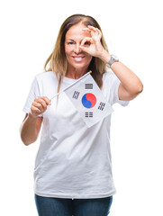 Wall Mural - Middle age hispanic woman holding flag of South Korea over isolated background with happy face smiling doing ok sign with hand on eye looking through fingers