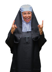 Poster - Middle age senior christian catholic nun woman over isolated background shouting with crazy expression doing rock symbol with hands up. Music star. Heavy concept.