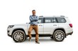 © darshika - Full length portrait of a man leaning on a SUV isolated on white background