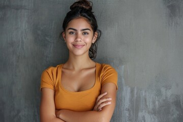 Canvas Print - Smiling Latin woman with crossed arms on grey wall.