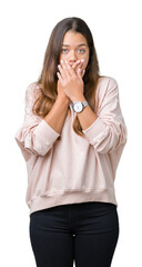 Canvas Print - Young beautiful brunette woman wearing pink sweatshirt over isolated background shocked covering mouth with hands for mistake. Secret concept.