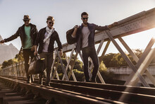 Group Of Friends Walking Across Train Bridge And Hanging Out Hobo Style. Paarl, South Africa