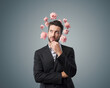© stokkete - Pensive businessman with piggy banks around his head