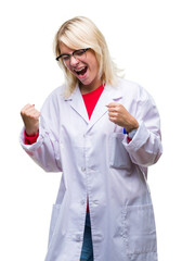 Poster - Young beautiful blonde professional woman wearing white coat over isolated background very happy and excited doing winner gesture with arms raised, smiling and screaming for success. Celebration.