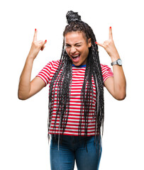 Canvas Print - Young braided hair african american girl over isolated background shouting with crazy expression doing rock symbol with hands up. Music star. Heavy concept.