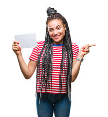 Wall Mural - Young african american girl holding blank card over isolated background very happy pointing with hand and finger to the side