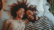 © Sasint - Interracial couple, laughing and relaxing on bed for morning bonding, funny relationship or joke at home.