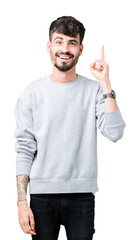 Wall Mural - Young handsome man wearing sweatshirt over isolated background pointing finger up with successful idea. Exited and happy. Number one.