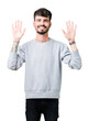 © Krakenimages.com - Young handsome man wearing sweatshirt over isolated background showing and pointing up with fingers number ten while smiling confident and happy.