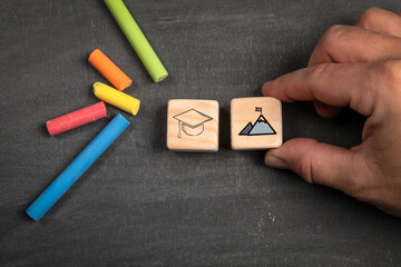 Wall Mural - education and career concept. wooden blocks on a dark chalkboard background