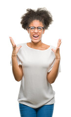 Sticker - Young afro american woman wearing glasses over isolated background crazy and mad shouting and yelling with aggressive expression and arms raised. Frustration concept.