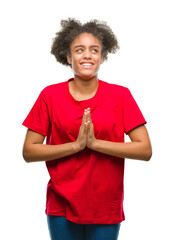 Wall Mural - Young afro american woman over isolated background begging and praying with hands together with hope expression on face very emotional and worried. Asking for forgiveness. Religion concept.