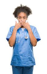 Wall Mural - Young afro american doctor woman over isolated background shocked covering mouth with hands for mistake. Secret concept.