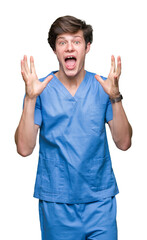Wall Mural - Young doctor wearing medical uniform over isolated background celebrating crazy and amazed for success with arms raised and open eyes screaming excited. Winner concept