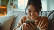 Smiling young beauty asian woman at home relaxed texting using mobile phone, technology communication concept