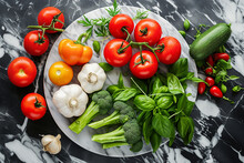 An  Arrangement Of Fresh Vegetables On A Black Marble Surface: Ripe Tomatoes, Garlic Bulbs, Green Basil Leaves, Broccoli Stems And A Zucchini. Ideal For Healthy Eating And Vegetarian Lifestyle Concept