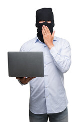 Canvas Print - Business hacker man holding a computer laptop cover mouth with hand shocked with shame for mistake, expression of fear, scared in silence, secret concept