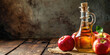 Artisan Apple Cider Vinegar with Fresh Apples, banner with copy space on wooden table. Rustic still life of apple vinegar in a glass bottle with apples on a wooden kitchen table.