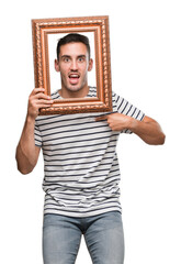 Sticker - Handsome young man looking through vintage art frame with surprise face pointing finger to himself