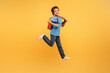 © Prostock-studio - Joyful boy jumping with backpack on vibrant yellow background