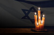 Six burning candles on Israel flag background.