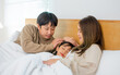 © Ann Rodchua - Three people of Asian family, father, mother, little daughter lying down, sleeping on bed in bedroom at cozy home with happiness, warmth. Residence, Kid, Housing, Healthcare Concept.
