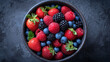 A visually stunning overhead view of a bowl filled with assorted berries, dominated by plump strawberries, creating a vibrant and colorful display of nature's bounty and delicious