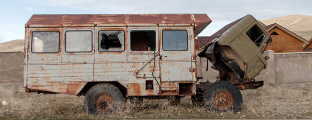 An old truck abandoned on the road with a rusty booth for transporting passengers