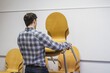 © Stefanie - Man stacking chairs in a conference room. Munich, Bavaria, Germany