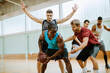 © Marko Geber - Young men playing basketball indoors