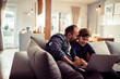 © Geber86 - Happy father and son having fun with laptop on the couch