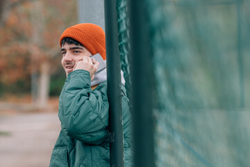 Wall Mural - young man in winter on the street talking on the mobile phone or cell phone