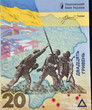 a detail of a current Ukrainian banknote with mention of the war