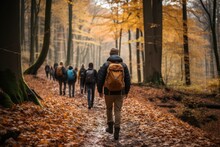 A Group Of Friends Embrace The Changing Season As They Traverse A Winding Trail Through The Colorful Woodland, Surrounded By Towering Trees And Crisp Autumn Air