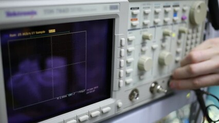 Digital oscilloscope and male hand pushes buttons for setting