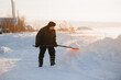 © Parilov - Elderly man cleaning snow with shovel after snowstorm, sunlight