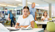 © JackF - Caucasian school student girl doing research on project laptop in the college library