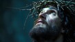 Jesus Christ with a crown of thorns looking at the sky with a crucified sad face. Catholic religion concept