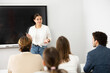 © JackF - Young female professor explaining subject to classroom full of students